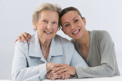 smiling female caregiver and her old blonded hair woman