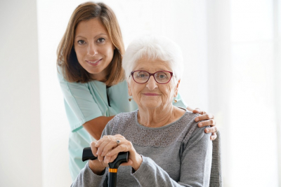 female caregiver with her old woman patient wearing eyeglasses