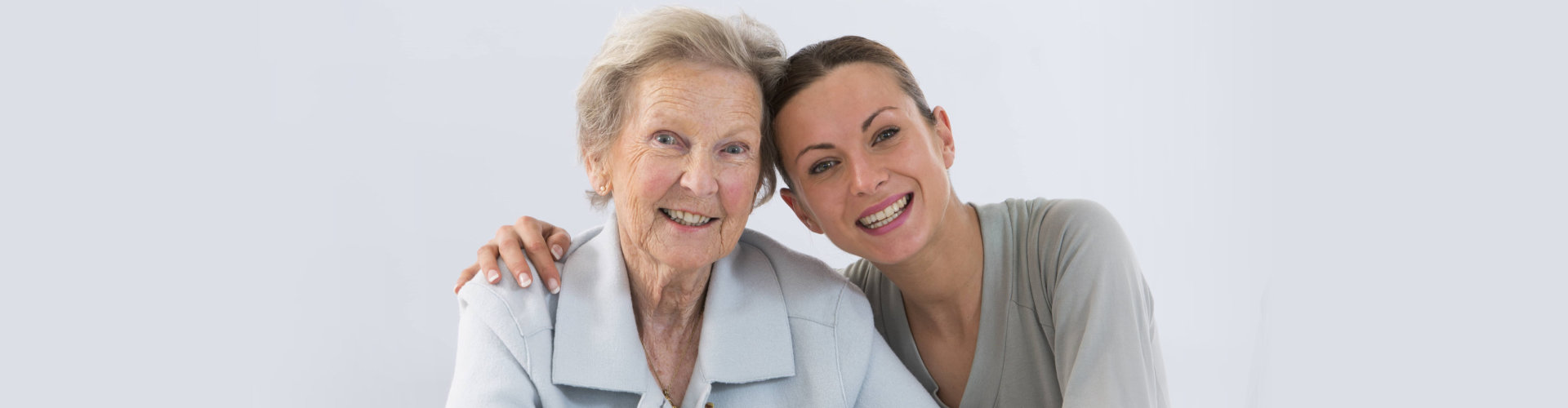 smiling female caregiver and her old blonded hair woman
